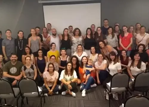 Pessoas no fundo de uma sala de treinamento tirando fotografia